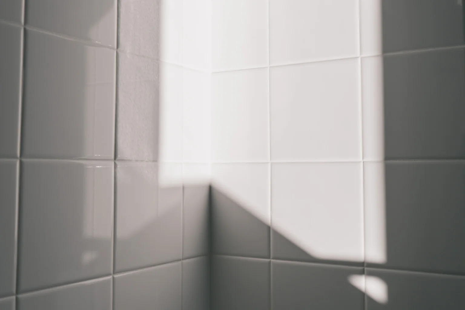 White ceramic bathroom wall tiles with realistic grout lines in natural daylight